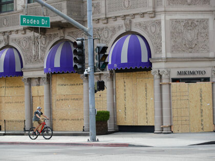 A man cycles past a boarded-up store a day after mass demonstrations over the death of Geo