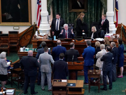 Texas Lt. Gov. Dan Patrick, seated center, talks to prosecution and defense attorneys after the prosecution rested in the impeachment trial for Texas Attorney General Ken Paxton in the Senate Chamber at the Texas Capitol, Wednesday, Sept. 13, 2023, in Austin, Texas. (AP Photo/Eric Gay)