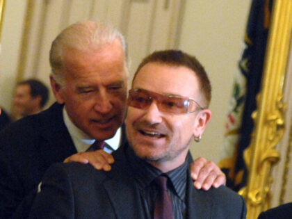 Musician Bono, gets a word from Sen. Joe Biden, D-Del., before a meeting of the Senate Foreign Relations Committee they discussed African debt relief. From left are Sens. Norm Coleman, R-Mnn., John Sununu, R-N.H., Dick Lugar, R-Ind., Biden, Bono, Sens. Ben Cardin, D-Md., and Bill Nelson, D-Fla.