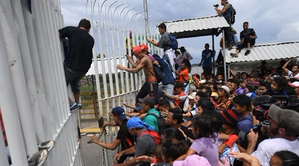Migrants climb the gate of the Guatemala-Mexico international border bridge in Ciudad Hidalgo, Chiapas. (FILE: Pedro Pardo/AFP/Getty Images)