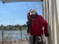 Watch: Migrant Crosses Border Carrying Child in Front of TV Interview with Congressman