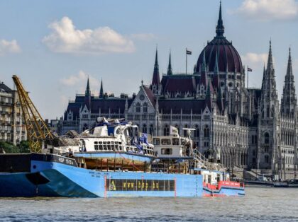The recovered sunken Mermaid sightseeing boat is transported past the Hungarian parliament building on the river Danube where it collided with a vessel in Budapest on June 11, 2019. - Hungarian police recovered more bodies after raising a sightseeing boat that sank in the river Danube in Budapest last month, …