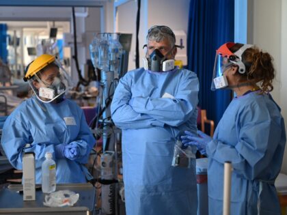 Members of the clinical staff wear personal protective equipment (PPE) as they care for patients at the Intensive Care unit at Royal Papworth Hospital in Cambridge, on May 5, 2020. - NHS staff wear an enhanced level of PPE in higher risk areas such as critical care to minimise the …