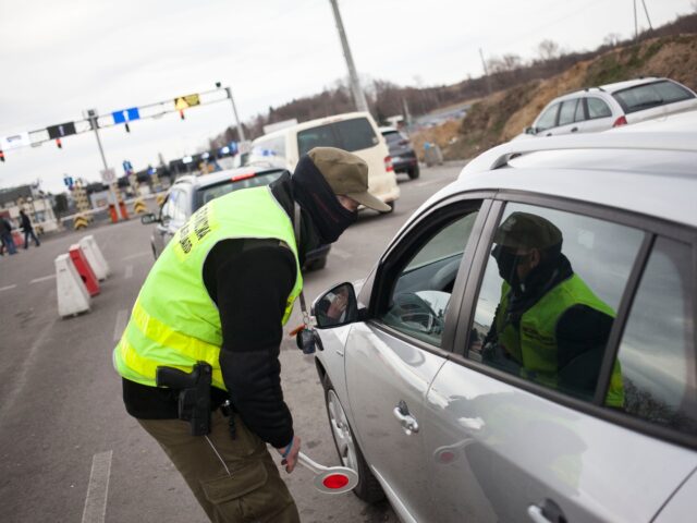 Polish border guard inspects car on Polish-Ukrainian border in Medyka, Poland on February