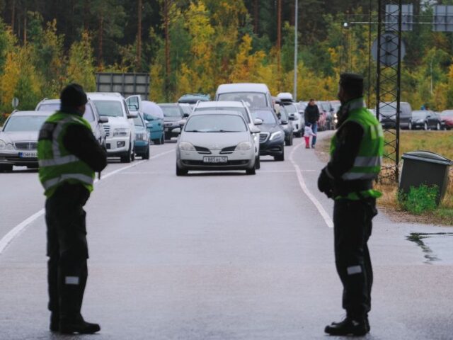 Finnish border guard officers look at cars queueing at the Vaalimaa border crossing betwee