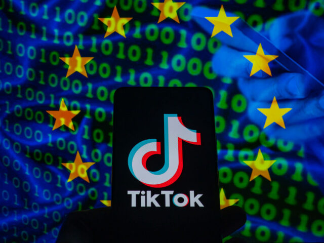 TikTok icon displayed on a phone screen with in the background European Union flag with cyber code, seen in this photo illustration. on 23 February 2023 in Brussels, Belgium. (Photo illustration by Jonathan Raa/NurPhoto via Getty Images)