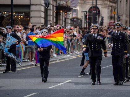 Participants in navy outfits march during The Pride in London Parade in London, UK, on Sat