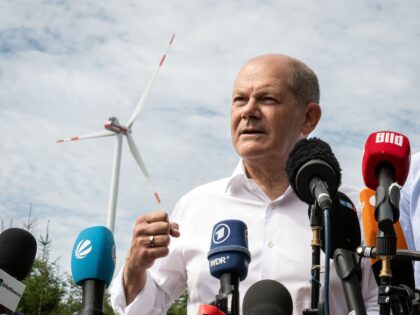 dpatop - 22 August 2023, North Rhine-Westphalia, Simmerath: German Chancellor Olaf Scholz (SPD) speaks to journalists during their visit to a community wind farm. The small town with more than 15,000 inhabitants makes profits by leasing the municipality's own forest land to the operator. Part of the income flows into …