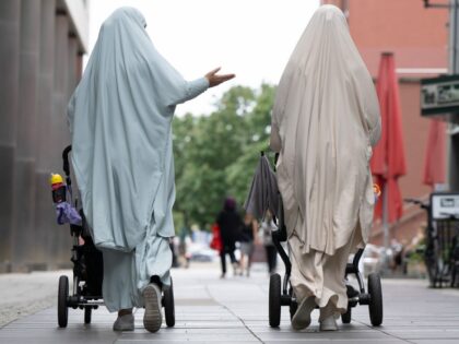 24 August 2023, Saxony, Dresden: Two women wearing a full body veil are each pushing a bab