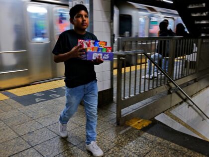 NEW YORK, NEW YORK - AUGUST 18: A young boy sells candy and other items in a New York City subway station on August 18, 2023 in New York City. Over 70,000 asylum-seekers have arrived in New York City since last year, according to City Hall, and many have taken …