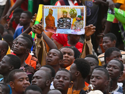 A man holds a placard with the image of Niger's new military ruler General Abdourahamane Tiani on as supporters of Niger's National Council of Safeguard of the Homeland (CNSP) protest outside the Niger and French airbase in Niamey on September 2, 2023 to demand the departure of the French army …