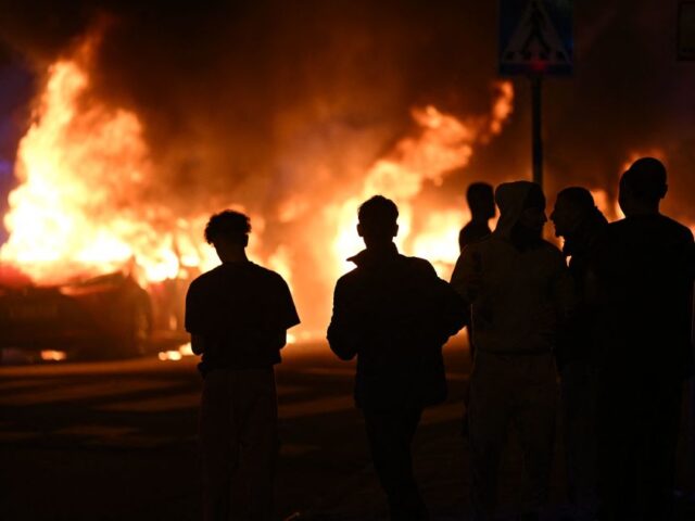 People look on as cars burn on Ramels vag in Rosengard, Malmo following a riot in the early hours of the morning on September 4, 2023. (Photo by Johan Nilsson/TT / various sources / AFP) / Sweden OUT (Photo by JOHAN NILSSON/TT/TT NEWS AGENCY/AFP via Getty Images)