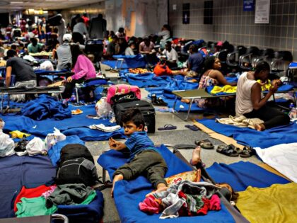 Recently arrived migrants sit on cots and the floor of a makeshift shelter operated by the city at O'Hare International Airport on Aug. 31, 2023. (Armando L. Sanchez/Chicago Tribune/Tribune News Service via Getty Images)