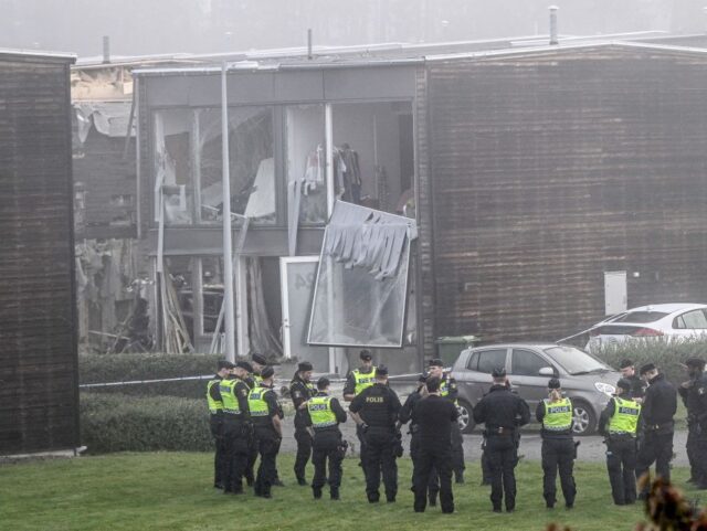 TOPSHOT - Policemen stand in front of a damaged building after a powerful explosion occurr