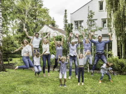 Three generational family jumping in garden