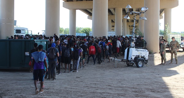 Border Patrol agents detain a group of migrants under the international bridge while awaiting transportation. (Randy Clark/Breitbart Texas)