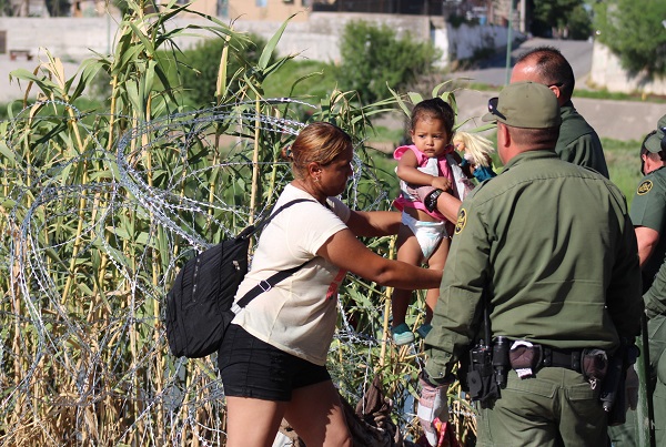 Border Patrol agents help migrant child through Texas razor wire. (Randy Clark/Breitbart Texas)