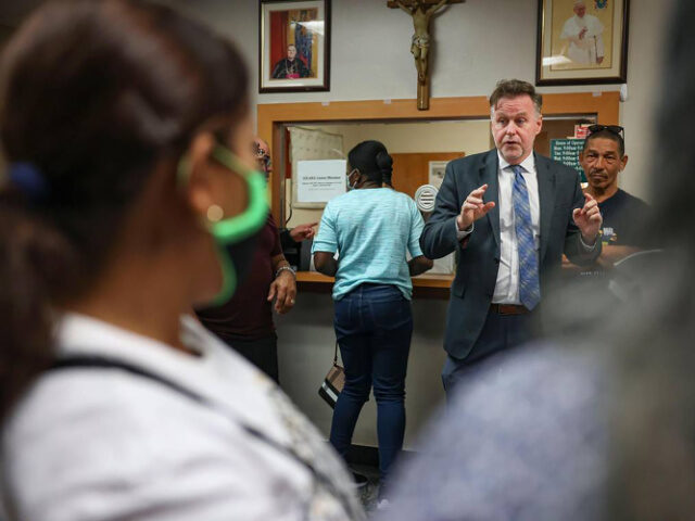 Randy McGrorty, co-founder of Catholic Legal Services, tries to organize 40 people waiting in the lobby, many of them migrants, inside Catholic Charities legal services on Monday, Jan. 9, 2023, in downtown Miami. (Alie Skowronski/Miami Herald/Tribune News Service via Getty Images)
