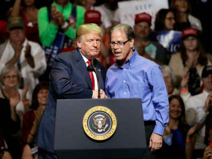 FILE - In this May 10, 2018 file photo, President Donald Trump, left, and Indiana Republican senatorial candidate Mike Braun shake hands as they embrace during a GOP campaign rally in Elkhart, Ind. Braun rails against foreign outsourcing on the campaign trail, even as his own company continues to sell …