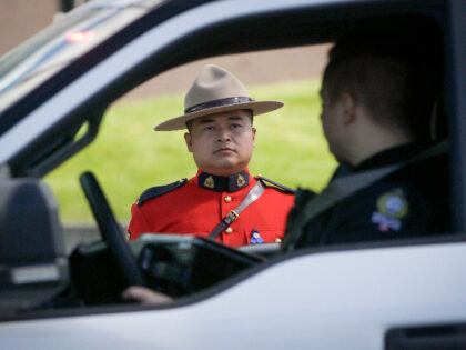 SURREY ,CANADA, April 30, 2020 .A police vehicle passes by a Royal Canadian Mounted Police ,RCMP, officer during a motorcade in Surrey, Canada, April 30, 2020. A memorial motorcade of first responders was held on Thursday in Surrey of Canada to honor the victims of the deadly Nova Scotia mass …