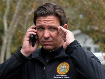 Florida Gov. Ron DeSantis talks on the phone with President Joe Biden as he stands outside storm-damaged restaurant Shrimp Boat during a visit to Horseshoe Beach, Fla., one day after the passage of Hurricane Idalia, Thursday, Aug. 31, 2023. (AP Photo/Rebecca Blackwell)