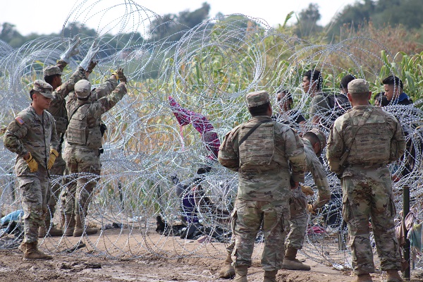 Texas National Guard soldiers install more razor wire in an attempt to hold migrants back. (Randy Clark/Breitbart Texas)