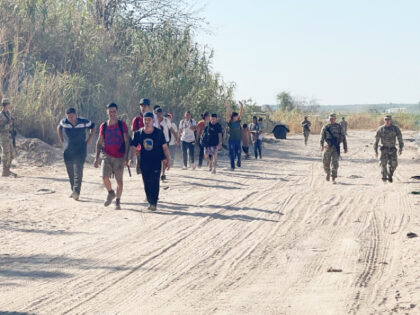 TMD soldiers escort migrants from border crossing to rally point. (Randy Clark/Breitbart T