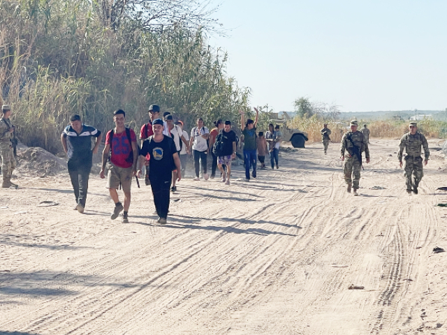 TMD soldiers escort migrants from border crossings to assembly points.  (Randy Clark/Breitbart, Texas)