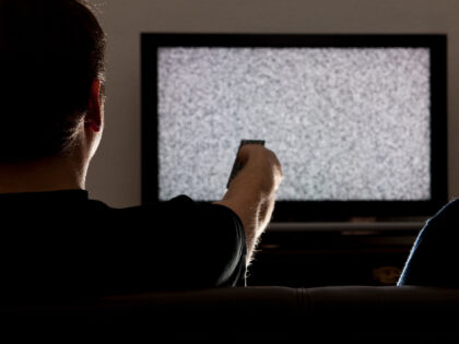 Two men watching static on television - stock photo