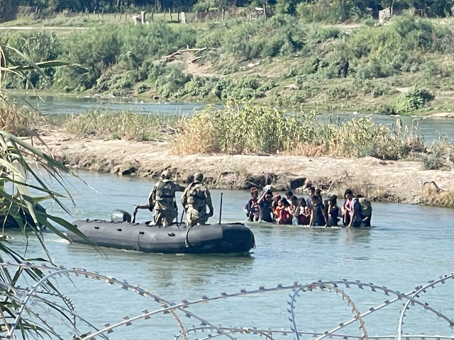 Texas state troopers try to stop a group of immigrants from crossing the border into Eagle Pass.  (Randy Clark/Breitbart, Texas)