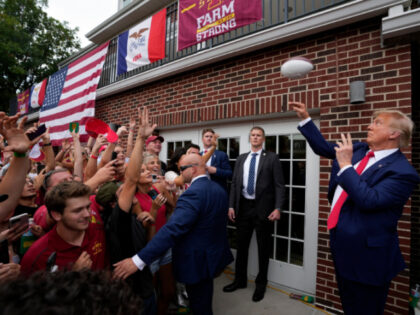 Former President Donald Trump throws a football to the crowd during a visit to the Alpha G