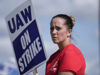 United Auto Workers member Victoria Hall walks the picket line at the Ford Michigan Assembly Plant in Wayne, Mich., Monday, Sept. 18, 2023. So far the strike is limited to about 13,000 workers at three factories — one each at GM, Ford and Stellantis. (Paul Sancya/AP)