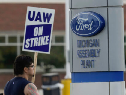 A United Auto Workers membera walk a picket line during a strike at the Ford Motor Company