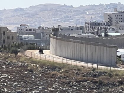 An Israeli Border Patrol vehicle drives along the patrol road near the wall outside Bethle
