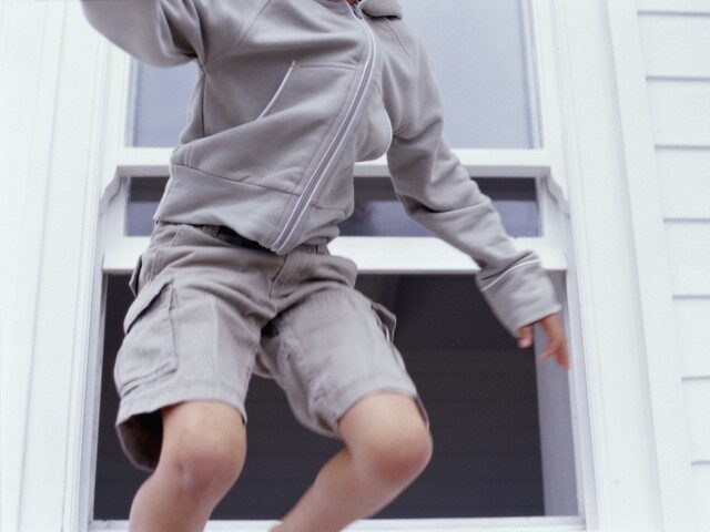 boy climbing out window