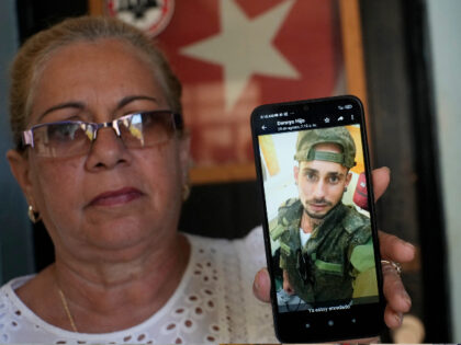 Marilin Vinent holds up a photo of her son Dannys Castillo dressed in military fatigues in an Aug. 22 message from her son that reads in Spanish "I'm already entangled" during an interview at her home in Havana, Cuba, Friday, Sept. 8, 2023. Vinent said that her son and other …