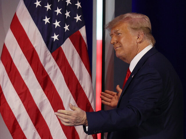 ORLANDO, FLORIDA - FEBRUARY 28: Former President Donald Trump embraces the American flag a