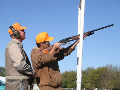 Wichita State student Dinh Dinh shoots clay targets under the eye of instructor Wayne Doyl