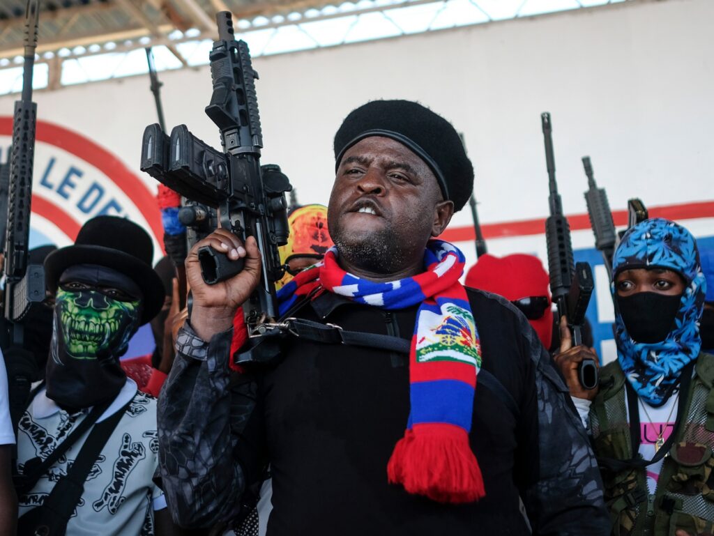 FILE - Leader of the "G9 and Family" gang, Jimmy Cherizier, better known as Barbecue, shouts slogans with his gang members after giving a speech, as he leads a march against kidnappings, through the La Saline neighborhood in Port-au-Prince, Haiti, Oct. 22, 2021. The U.N. Security Council unanimously adopted a resolution Friday, Oct. 21, 2022 demanding an immediate end to violence and criminal activity in Haiti and imposing sanctions on Barbecue, a former police officer. (AP Photo/Matias Delacroix, File)