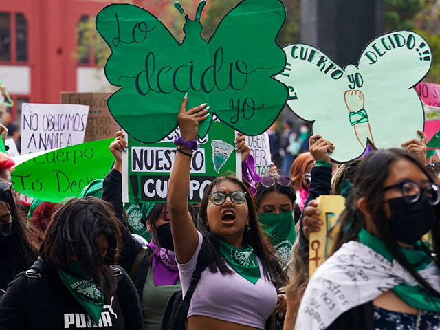 A woman holds up a sign with a message that reads in Spanish; "I will decide" as