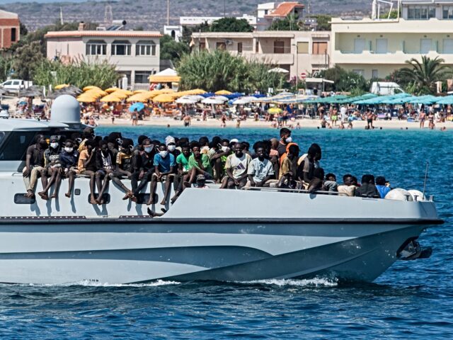 TOPSHOT - New migrants arrive on a Guardia di Finanza ship, in the harbour of Italian isla