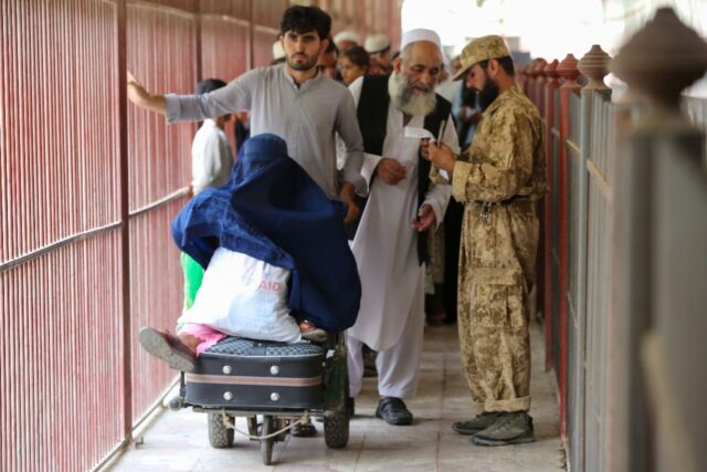 Afghans have their documents checked as they cross to Pakistan after the Torkham border cr