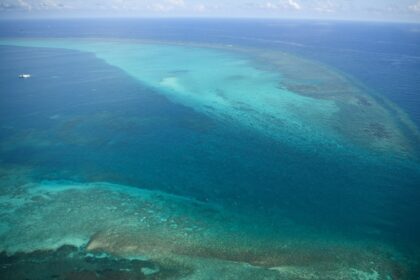 Chinese coast guard ships are seen (top L) anchored inside the lagoon of the Scarborough S