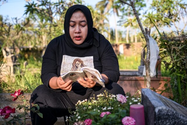 Cholifatul Noor prays at the grave of her only child, Jovan Farellino, who was 15 when he