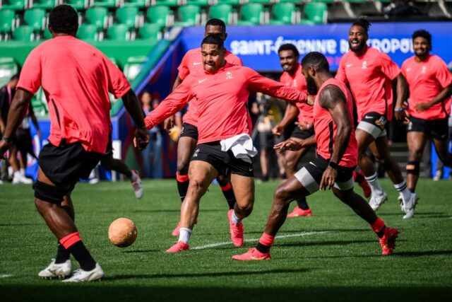Fiji hooker Sam Matavesi (centre) and his teammates play football to warm-up during a trai