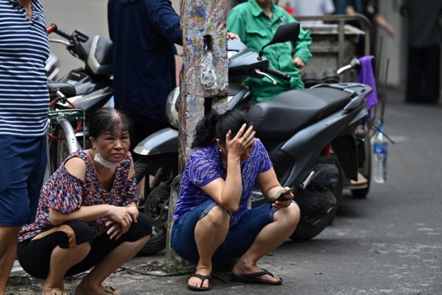 Hundreds gather outside a Hanoi morgue to hear if their families were victims of a fire th
