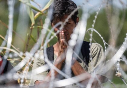 A migrant from Venezuela prays after crossing the Rio Grande to Eagle Pass, Texas