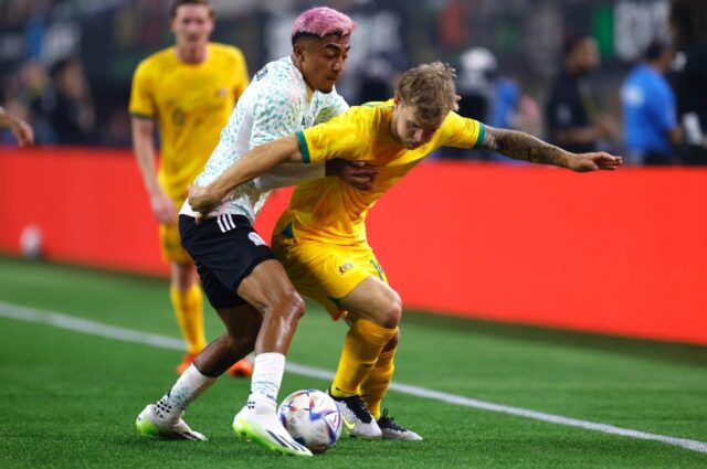 Riley McGree (R) of Australia tussles with Julian Araujo of Mexico during the first half o