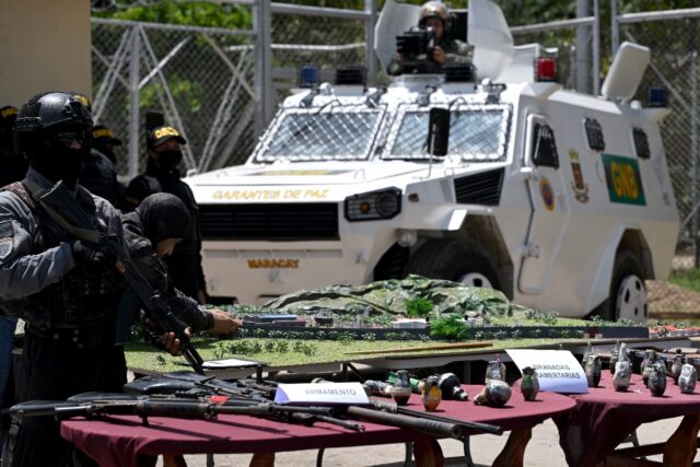 Venezuelan authorities show off the weapons they seized when they stormed the gang-held To