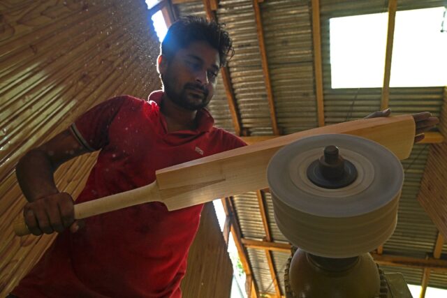A worker crafts a Kashmiri willow wood cricket bat at a factory in Kashmir's Sangam villag